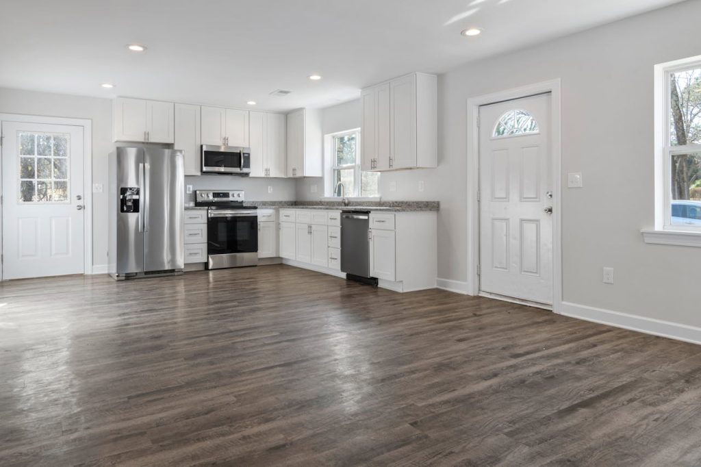pexels photo 6510983 Spacious and clean minimalist kitchen featuring stainless steel appliances and wooden flooring.