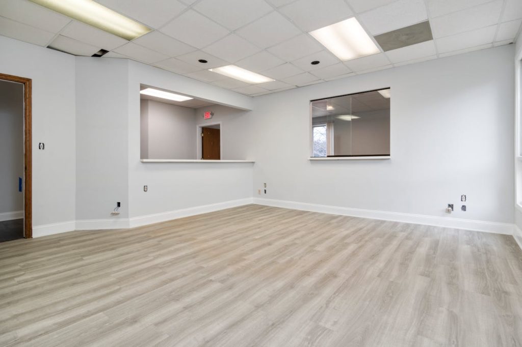 pexels photo 7028110 Modern and spacious empty room with wooden flooring and recessed lighting.